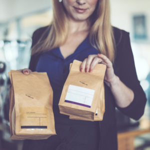 Woman holding finished bags of coffee